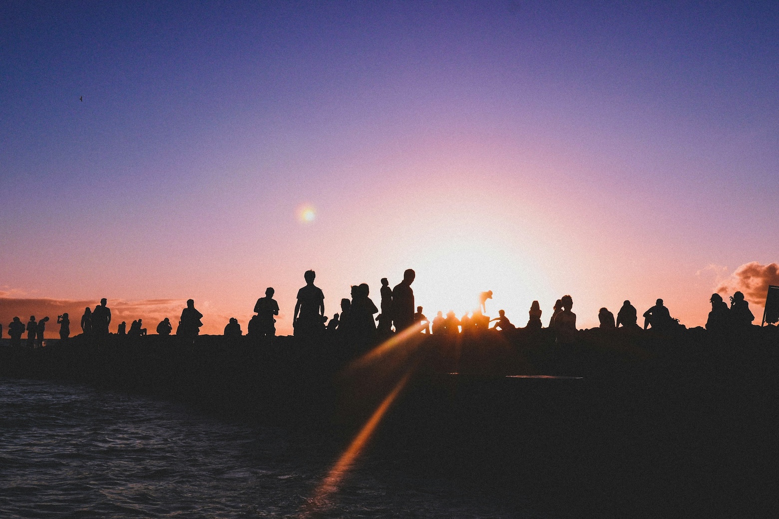 image of silouhette of a group of people standing watching sunset